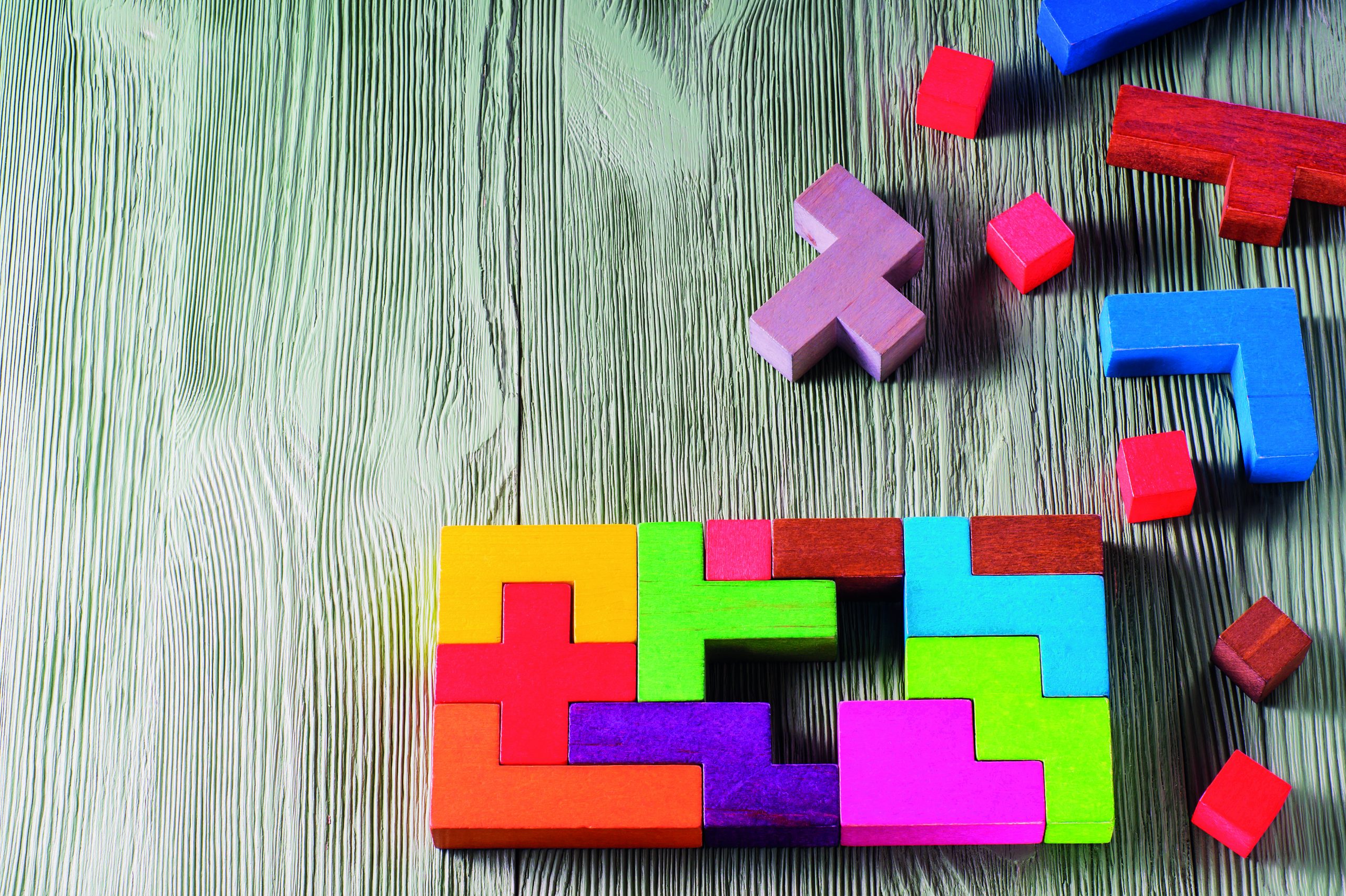 The concept of logical thinking. Geometric shapes on a wooden background. Tetris toy wooden blocks.