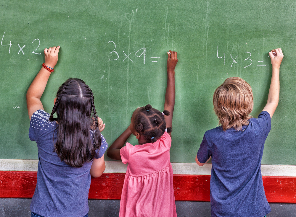 jovem professora ensinando aula de matemática para alunos na sala