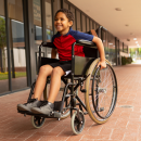 disabled-schoolboy-sitting-on-wheelchair-in-corrid-2021-08-28-16-44-09-utc