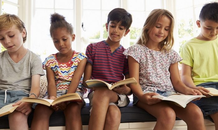 Group Of Multi-Cultural Children Reading On Window Seat
