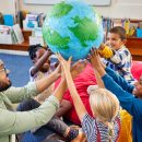 Group,Of,Multiethnic,Children,With,Male,Teacher,Holding,Model,Of