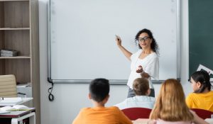 African,American,Teacher,Pointing,With,Hand,While,Standing,Near,Whiteboard