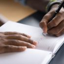 African,Man,Sit,At,Desk,Hold,Pen,Keeps,Startup,Business