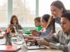 Teacher,Teaching,Diverse,School,Kids,Using,Laptop,In,Classroom.,African