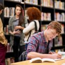 Student,,Writing,And,Notebook,In,Library,For,Study,,Education,And