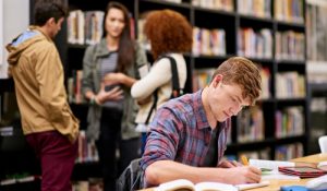 Student,,Writing,And,Notebook,In,Library,For,Study,,Education,And