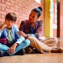 African,American,Teacher,Talking,To,Sad,Elementary,Student,In,A