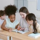 Happy,Teacher,And,Group,Children,Diversity,In,Classroom,,Attentively,Following