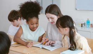Happy,Teacher,And,Group,Children,Diversity,In,Classroom,,Attentively,Following