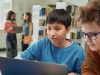 Portrait,Of,Young,Boy,Using,Laptop,In,School,Library,With