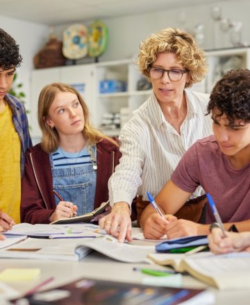 Multiethnic,Teenagers,Students,Focused,On,Learning,As,Teacher,Provides,Guidance