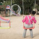 Lonely,Girl,Sitting,On,Chain,Swing,In,The,Park