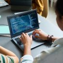 Teenage,Black,Girl,Coding,On,Laptop,,Sitting,At,Desk,With