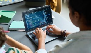 Teenage,Black,Girl,Coding,On,Laptop,,Sitting,At,Desk,With