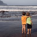 Two,Young,Boys,,Brothers,Or,Friends,,Stand,Hugging,On,Beach