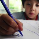 Young,Boy,Focusing,On,Tracing,Words,On,A,Worksheet,,Developing