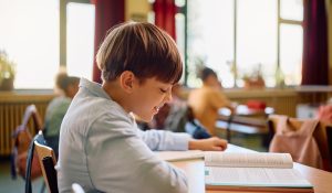 Happy,Schoolboy,Reading,From,A,Book,During,A,Class,In