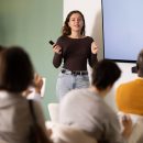 Young,Woman,Teacher,Gives,Lecture,To,Multinational,Group,Of,Students