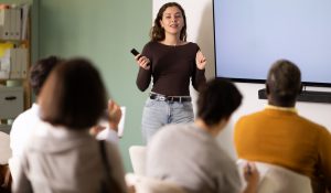 Young,Woman,Teacher,Gives,Lecture,To,Multinational,Group,Of,Students