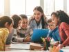 Happy,Female,Teacher,Assisting,Students,In,Classroom,,Educating,Children,,Learning